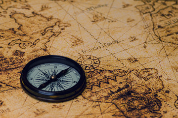Fototapeta na wymiar vintage lifestyle concept: retro compass on antique world map