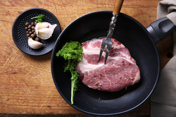 Marbled beef steak on pan and spices on wooden background