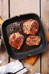 Roasted beef fillet on pan, on wooden background