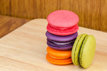 Tasty Sweet Macaroons on wooden background.