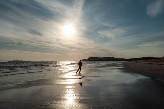 a man jogging at the beach at sunrise