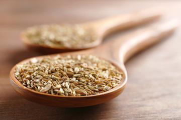 Cumin in wooden spoon on the table, close-up