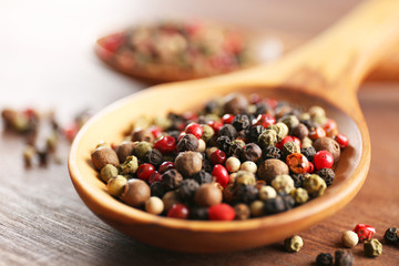 Pepper in wooden spoon on the table, close-up