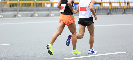 Fototapeta premium Marathon runners running on city road