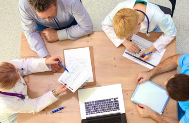 Male and female doctors working on reports in medical office