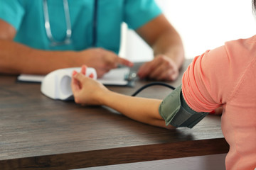 Male doctor examining patient blood pressure
