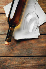 Bottle of wine with glass and corkscrew on wooden background