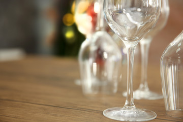 Construction of empty wine glasses on wooden table against blurred background