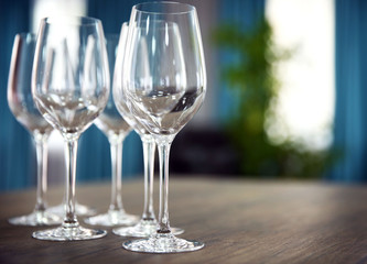 Empty wine glasses on wooden table against blurred background