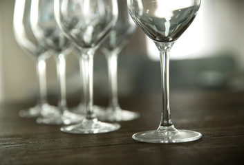Empty wine glasses on wooden table against blurred background