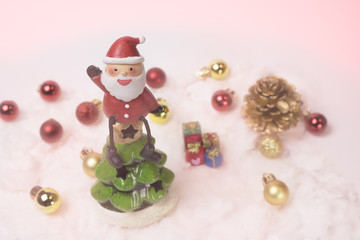 Santa claus sits on the top of the christmas tree with pink filt