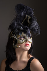 Beautiful young teenage girl in black mysterious Venetian mask. Fashion photo