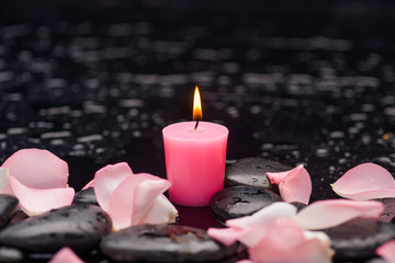 pink rose petals with pink candle and therapy stones 