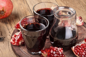 Pomegranate juice on a wooden table closeup. Copy space