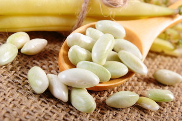 Seeds and stack of yellow beans on jute canvas, healthy food