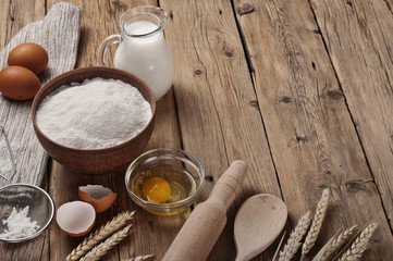 Flour, egg, milk on wooden table rustic kitchen