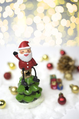 Santa claus sits on the top of the christmas tree.