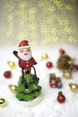 Santa claus sits on the top of the christmas tree.