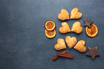 Heart shaped biscuits with dried spices on dark grey background