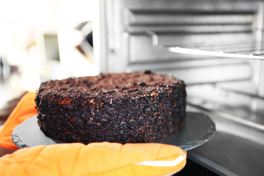 Housewife Preparing Chocolate Cake In Oven, Close Up