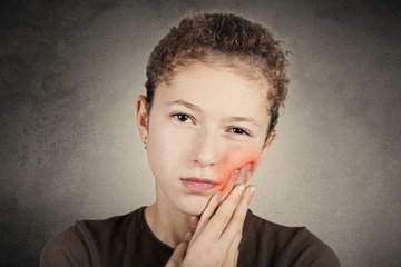 Portrait of a Young girl with toothache over white background.Child toothache with sensitive tooth...