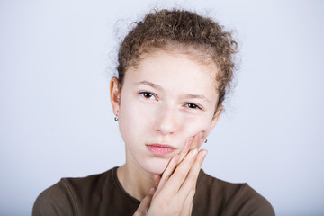 Portrait of a Young girl with toothache over white background.Child toothache with sensitive tooth...