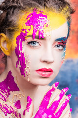 Portrait of beautiful young woman with paint on face 
