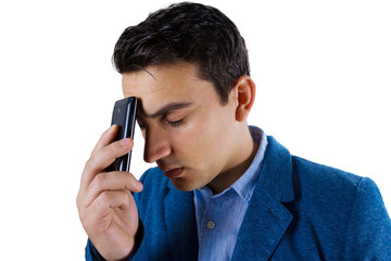 Closeup portrait of depressed, worried young man, student holding the phone on his head, isolated on white background.Distress young man talking on phone.