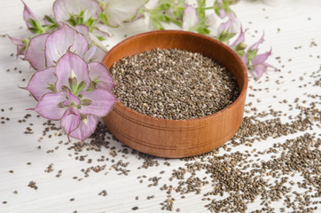Chia seed healthy super food with flower over white wood backgro