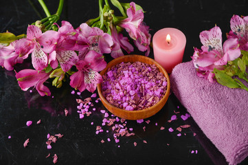 Spa and wellness setting with salt, candles and towel, petals