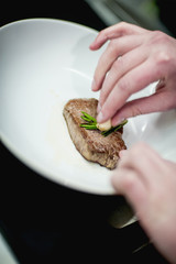 beefsteak in a plate with rosemary and garlic