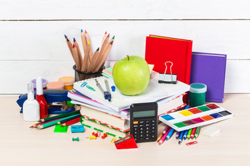 Group of school supplies and books over a white background