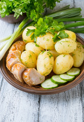 Young boiled potatoes with dill, sausage, cucumber, parsley and