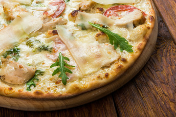 Delicious pizza with chicken, parmesan and fresh arugula