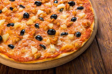 Delicious pizza with pineapple, chicken and olives