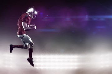Composite image of american football player holding ball 