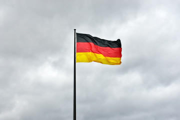German flag waving on the wind in gray cloudy day - 97788421