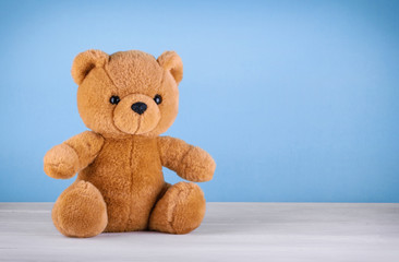 Toy teddy bear on blue background with copy space