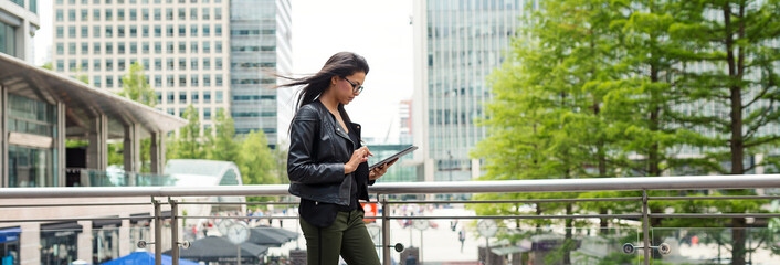 Panoramic image of young mixed race businesswoman portrait outdoors in Canary Wharf in London.