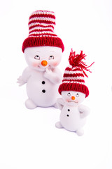 Два белых снеговика в шапках на белом фоне
