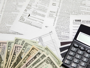 Credit card, calculator and dollars on tax form