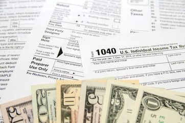 individual tax forms with dollar bills