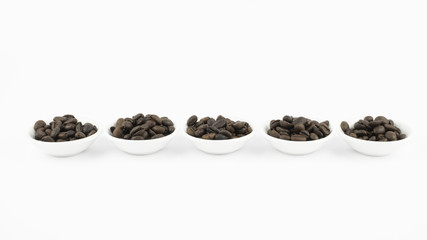 Coffee beans in white bowl on white background isolated