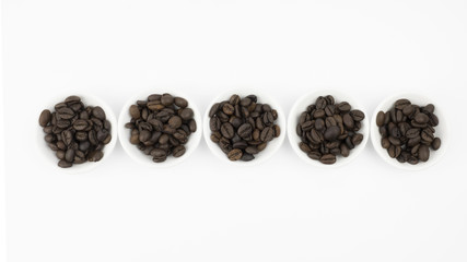 Coffee beans in white bowl on white background isolated