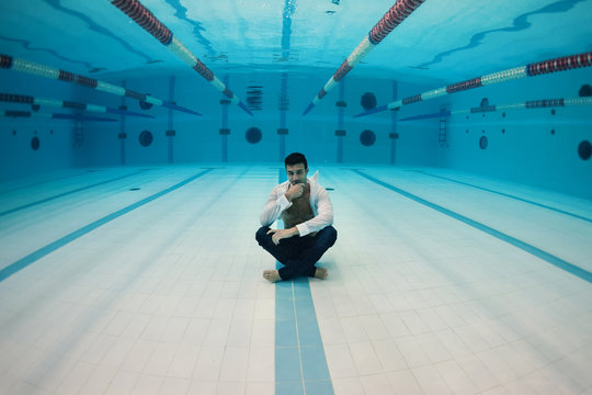 Man Portrait Wearing White Shirt Inside Swimming Pool. Underwate