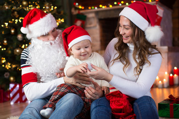 Happy family having a fun near Christmas tree and fireplace  in living room