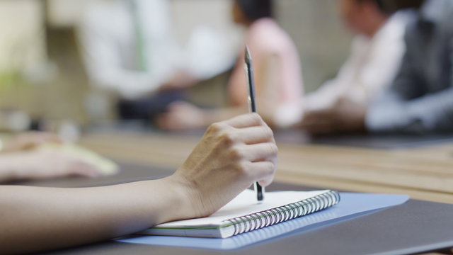  close up hand of businesswoman tapping her pen in a boardroom meeting