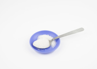 Sugar is in the spoon over white background