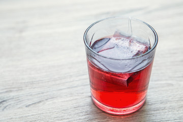 bicchiere trasparente con acqua calda e bustina di tisana 