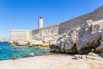 Pier, fortifications and a lighthouse on the island of If. In the background, Marseille, France